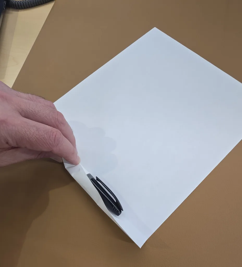 Roll paper tightly around pen
