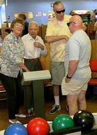 a group of seniors gathered at a bowling alley