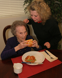 Picture of adult daughter helping mother eat