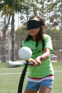 low vision girl with playing t-ball