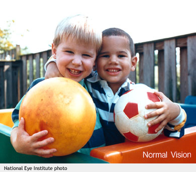 Dos niños abrazados que sujetan pelotas