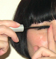 rest the point of the mascara wand against your index finger
