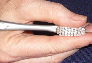 Hold toothbrush bristles between your index finger and thumb to serve as a guide