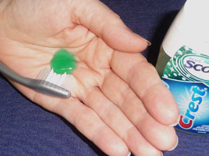 Dispense toothpaste in your palm and then scoop it out with the toothbrush