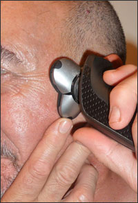 Hand razor being guided over side of head