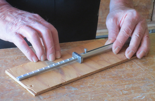 closeup of someone using the Click Rule to measure a board