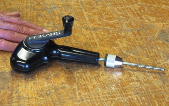Hand-operated drill with crank