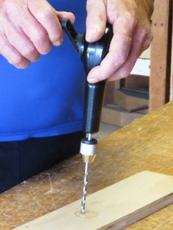 Hand-operated drill in use