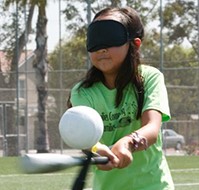 low vision girl with playing t-ball