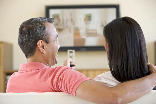 couple smiling while watching TV