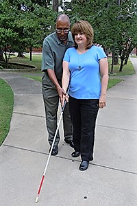 Orientation and Mobility instructor shows a woman how to use her white cane