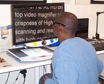 man looking at screen of screen magnifier