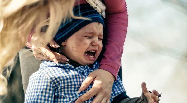 Mother leaning down to her crying son