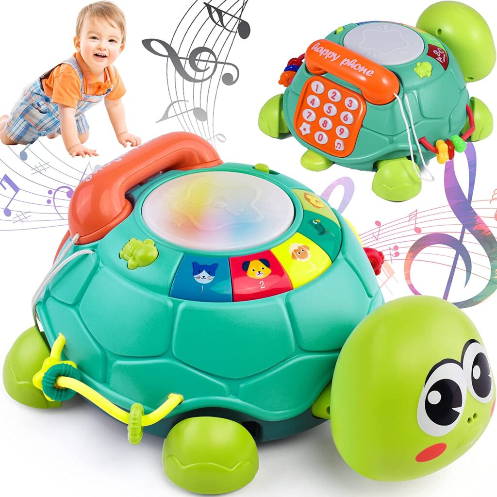 A boy crawling behind the light up musical turtle with a phone with numbers on its back.  