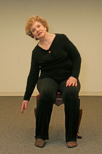 Person bends to the side reaching down toward the floor with right hand.