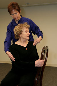 A. Begin in starting position, standing or sitting. B. Rotate at the waist to the right, reaching around the body with the left arm. C. Turn the head to the right. D. If standing, keep shoulders, knees, and hips relaxed. They will move slightly as well. E. Repeat to the left. Hold the stretch 5 to 10 seconds.