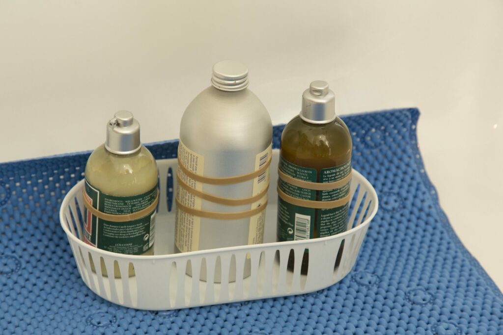 container with three body products, each with a different number of rubber bands for distinguishing bottles by touch