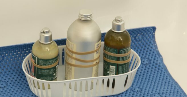 container with three body products, each with a different number of rubber bands for distinguishing bottles by touch