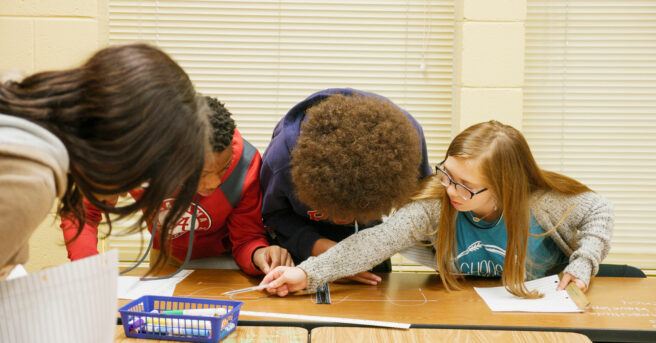 Three students working together on a science project.