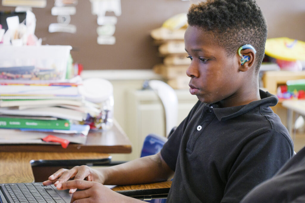 Student that is deafblind working on a computer.