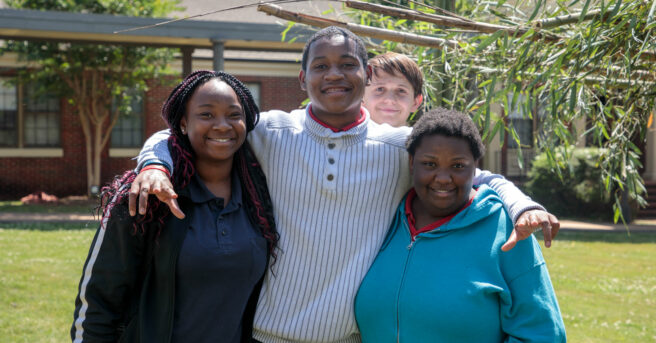 A group of four students smiling.
