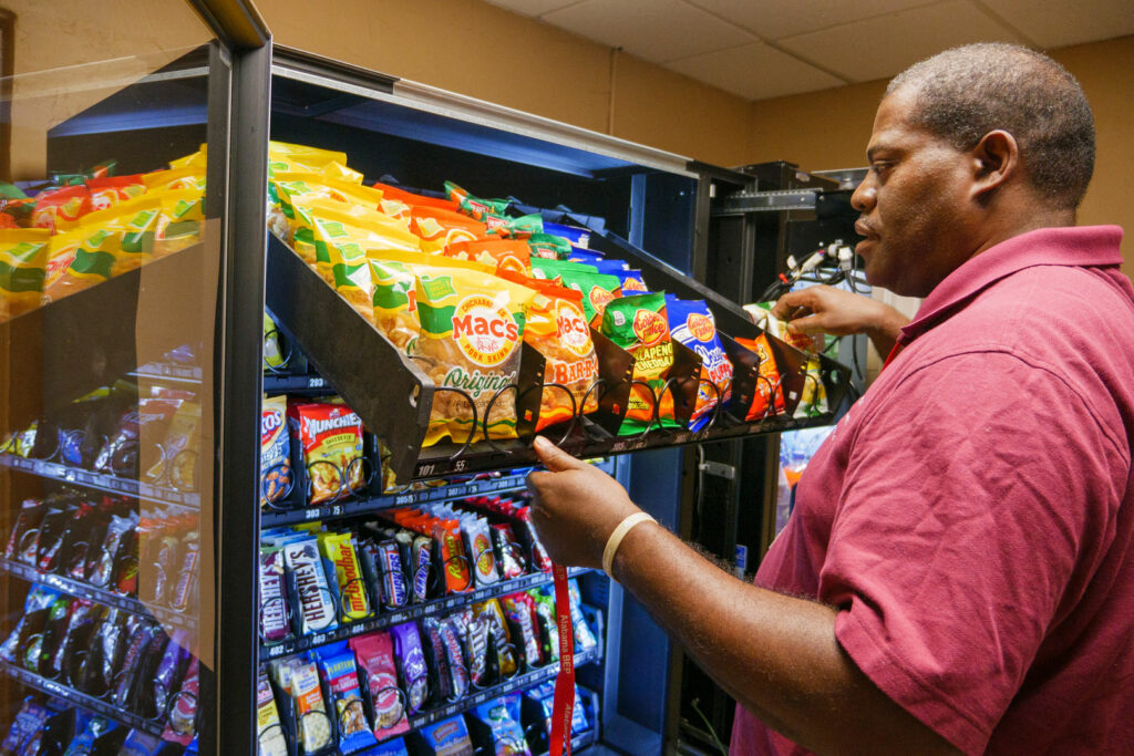 A man stocking a vending machine.