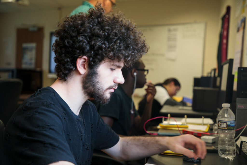 A young adult working at a computer.