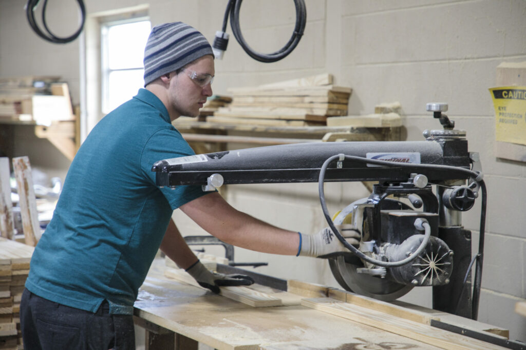 A teen working in a woodshop.