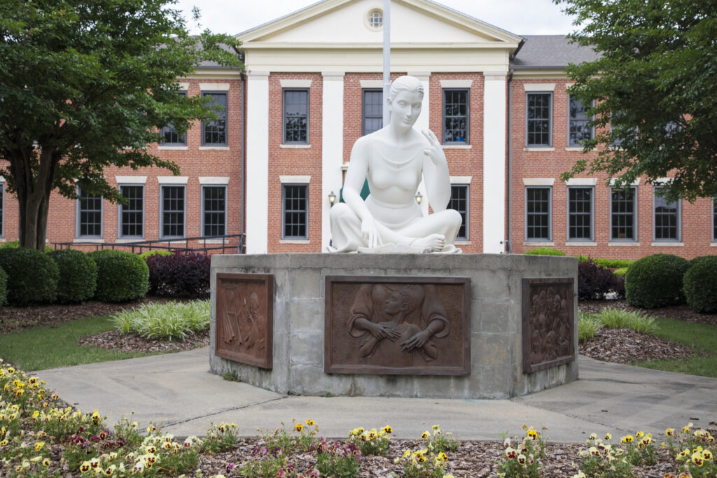 Outside of school building with statue.