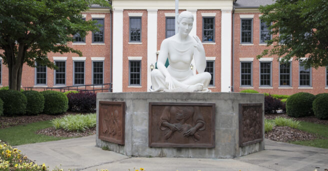 Outside of school building with statue.