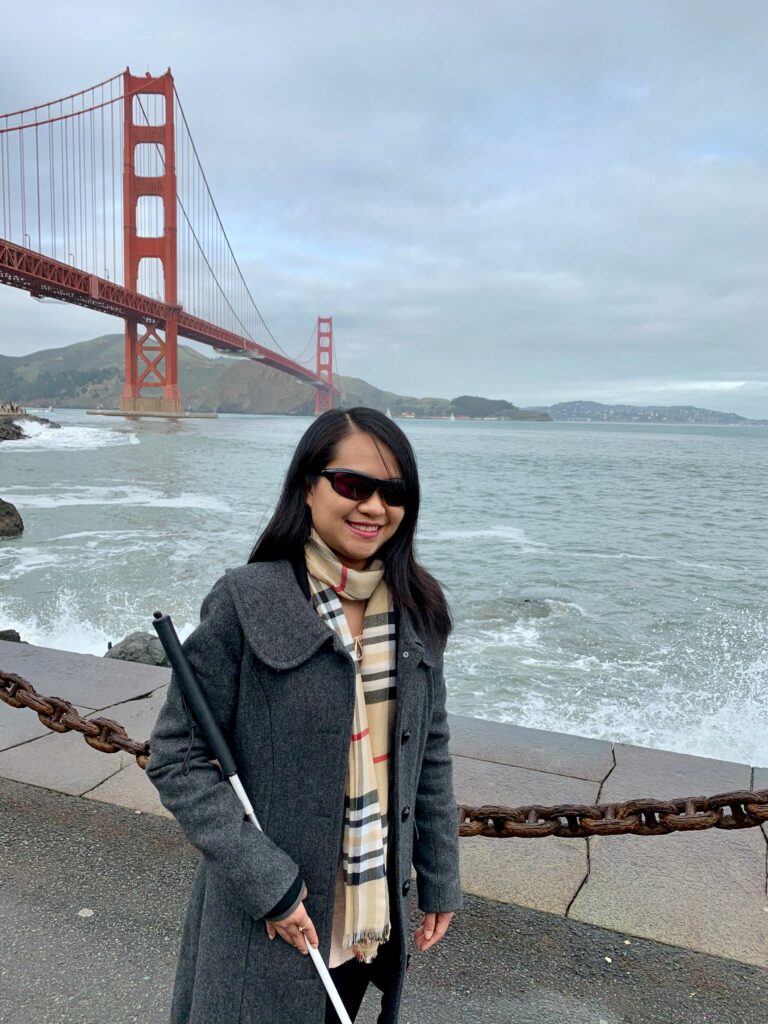 Image of Author Ann Wai-Yess Kwong posing with San Francisco Golden Gate Bridge behind her.