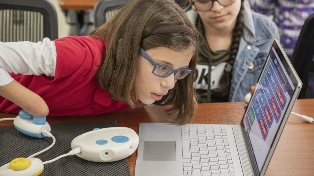 Female student using Coder Jumper with a laptop