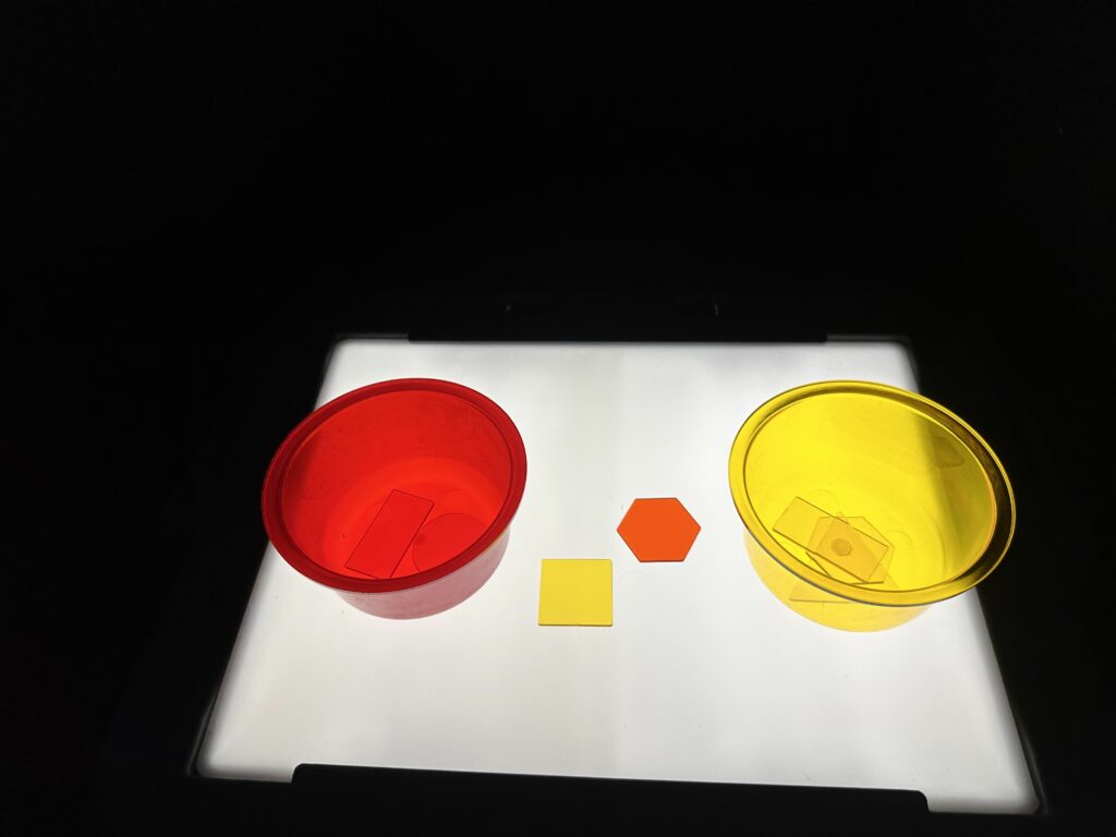 The second photo shows red and yellow transparent shapes ready to be sorted into a transparent red bowl or a transparent yellow bowl lying flat on a lightbox. 