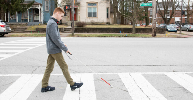 Individual Using White Cane on a crosswalk.