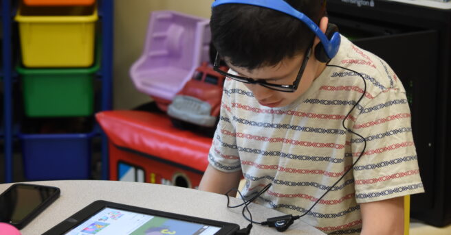 Student with iPad and headphones