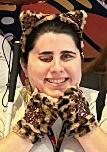 dark haired woman wearing cheetah ear headband and cheetah print gloves