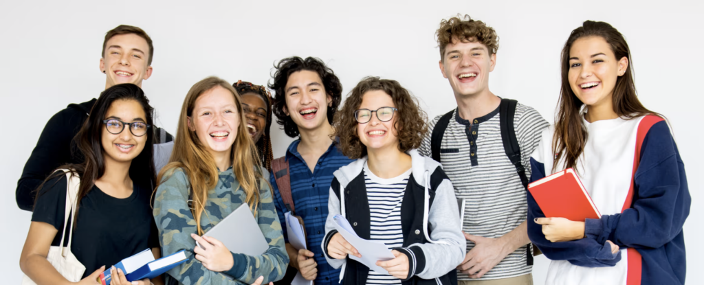 Group of 8 students smiling and holding papers and books