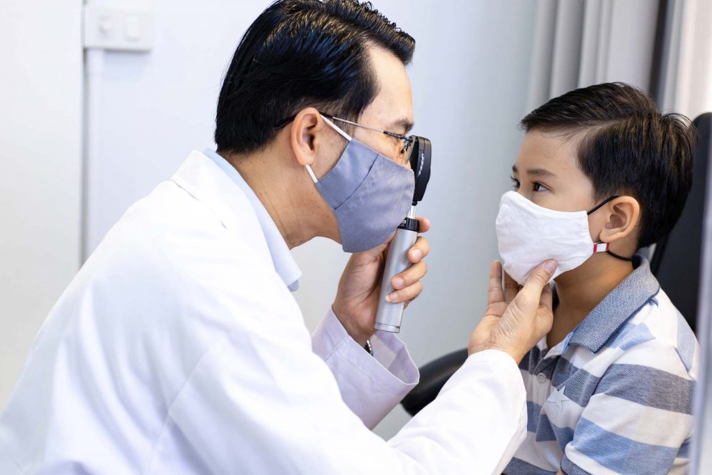 Eye Doctor Wearing Mask Examining Child with Mask