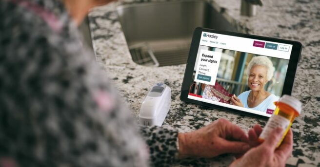 Person Looking at the Hadley Website on a Tablet and viewing a prescription bottle