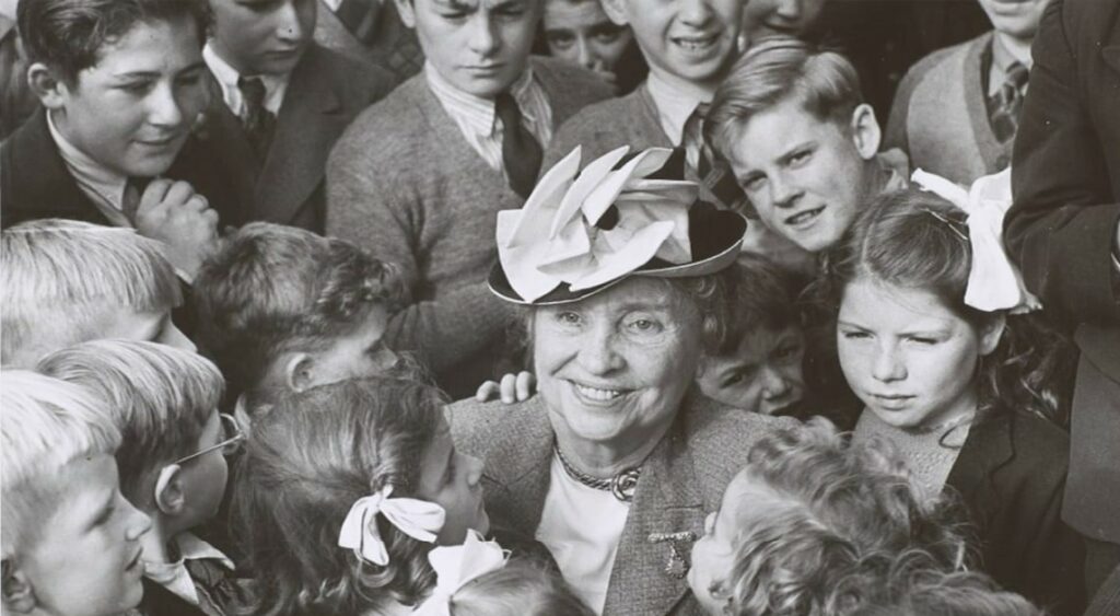 Helen Keller surrounded by a crown of young people