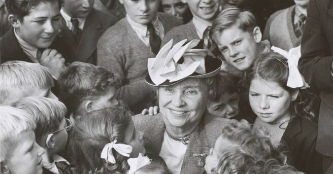 Helen Keller surrounded by a crown of young people