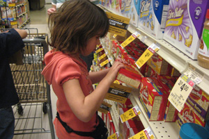 Rachel taking popcorn off shelf in grocery store