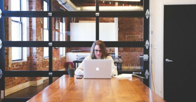 Individual at table working on a laptop