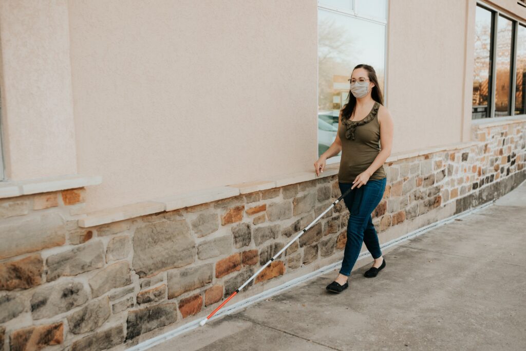 Adult trailing a wall with a cane