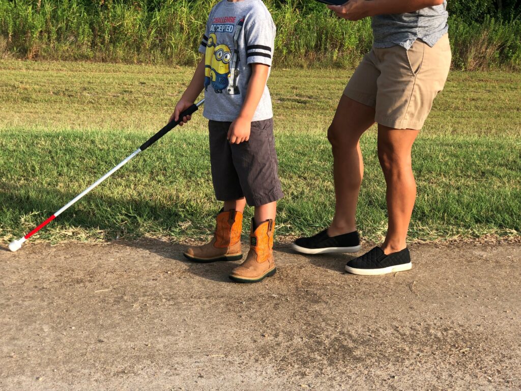 Elementary-age child trailing with a cane