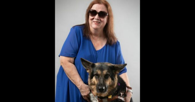 Kim Charlson with arms around a German Shepherd dog guide