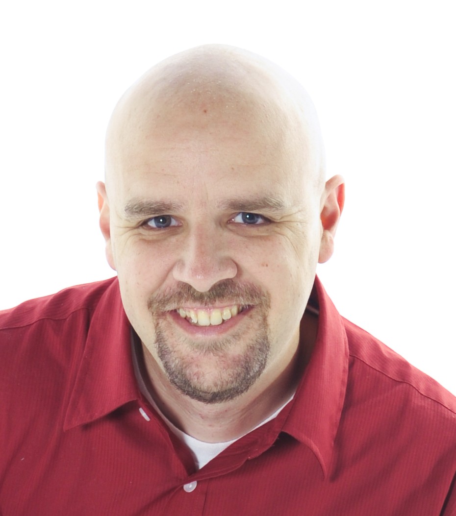 Smiling bald man with a close trimmed goatee wearing a red, button down shirt