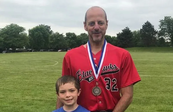 Michael Finn wearing a trophy on a field.