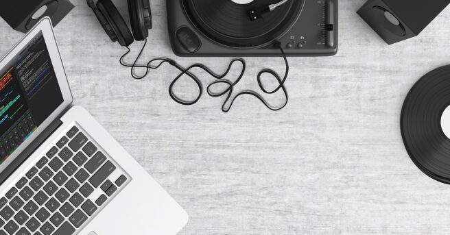 Laptop, turntable, and headphones rest on a table