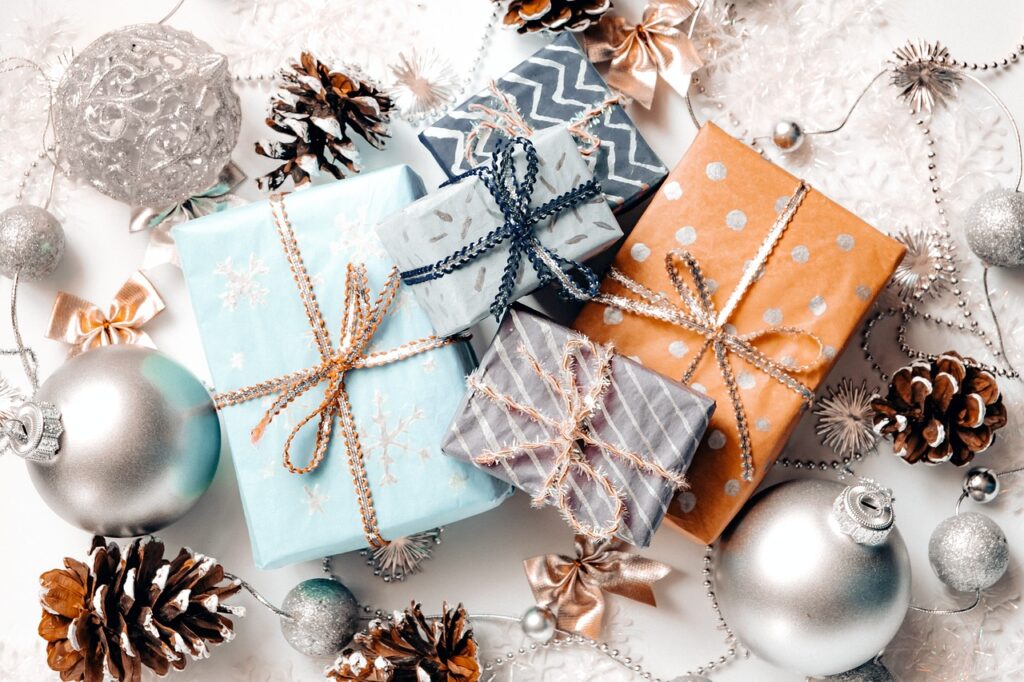 Wrapped gifts surrounded by Christmas ornaments and pine cones
